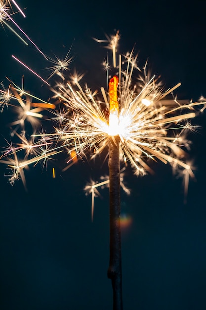 El fuego de Bengala de Navidad brilla contra el fondo negro.