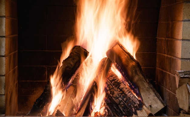 Fuego en la chimenea vacaciones de invierno en casa de campo