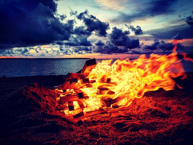 Fuego en una estructura de madera contra el cielo durante el amanecer