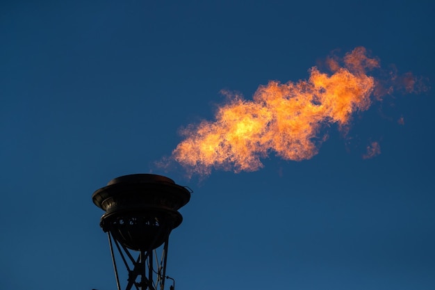 Un fuego de gas ardiente brota de un gran quemador de gas de una columna rostral en San Petersburgo, Rusia