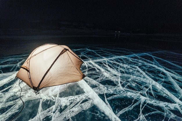 Fuego en el hielo por la noche Campamento en el hielo Tienda de campaña junto a la hoguera Lago Baikal