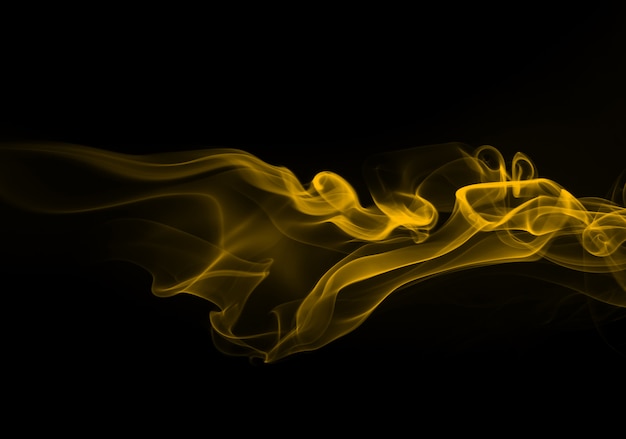 Fuego de humo amarillo abstracto sobre fondo negro para el diseño. concepto de oscuridad