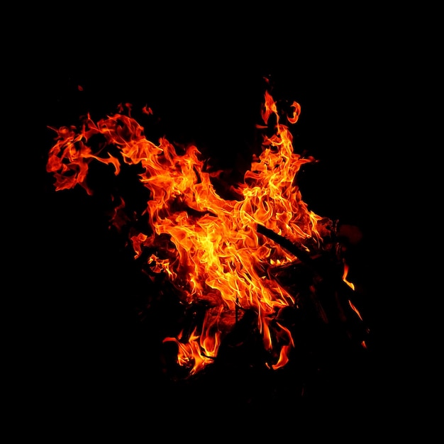 Fuego de llama que quema aislado en fondo oscuro con fines de diseño gráfico