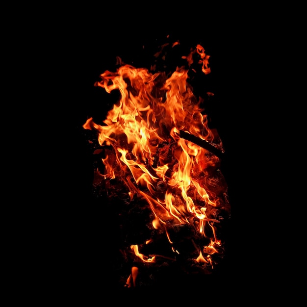 Fuego de llama que quema aislado en fondo oscuro con fines de diseño gráfico