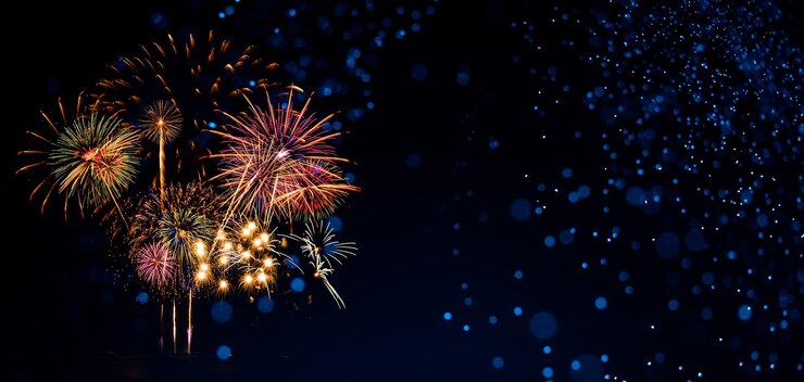 Fuegos artificiales en el cielo nocturno con fondo azul.