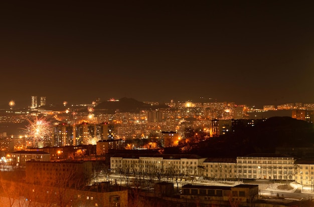 Fuegos artificiales en la ciudad por la noche durante la celebración del año nuevo fondo de enfoque suave