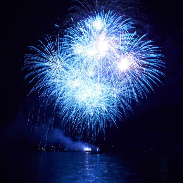 Fuegos artificiales de colores azules en el fondo del cielo negro