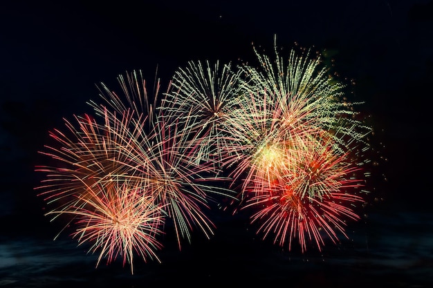 Fuegos artificiales de colores brillantes sobre un fondo negro. Concepto de celebración y vacaciones. Año Nuevo, Día de la Independencia, Festival 4 de julio. Brillantes explosiones de luces en el cielo. Lugar para su texto.