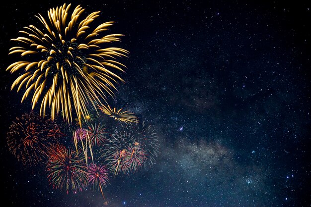 Fuegos artificiales con un fondo borroso de la Vía Láctea