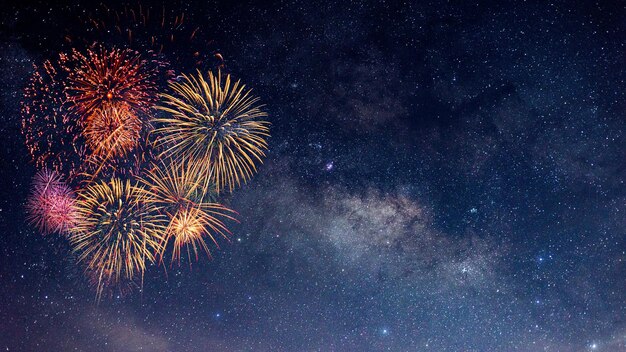 Fuegos artificiales con un fondo borroso de la Vía Láctea