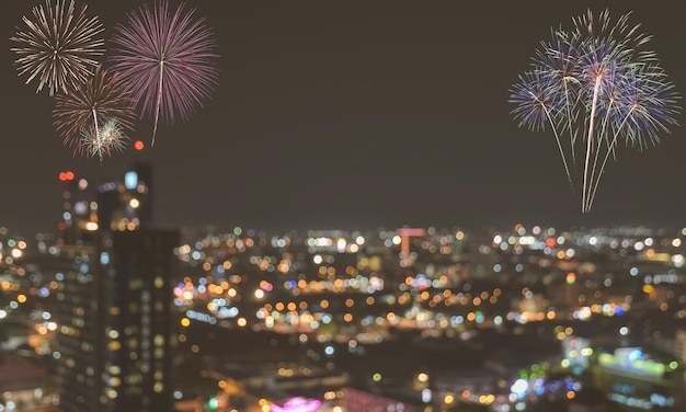 Fuegos artificiales sobre fondo de cielo crepuscular borroso con luces de ciudad coloridas bokeh. Imagen de efecto de filtro vintage