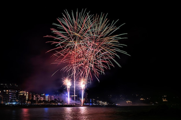 Fuegos artificiales de vacaciones en la ciudad de la costa.