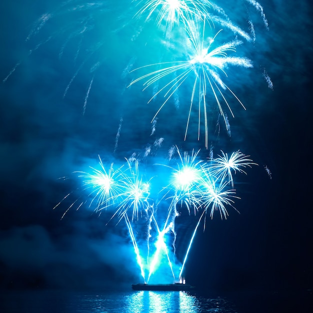 Fuegos artificiales de vacaciones de colores azules en el cielo negro