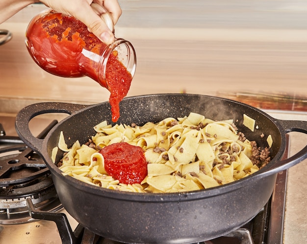 Fügt Spaghetti mit Hackfleisch Tomatensauce hinzu, gebraten in einer Spaghetti-Bolognese-Pfanne nach Rezept aus dem Internet.