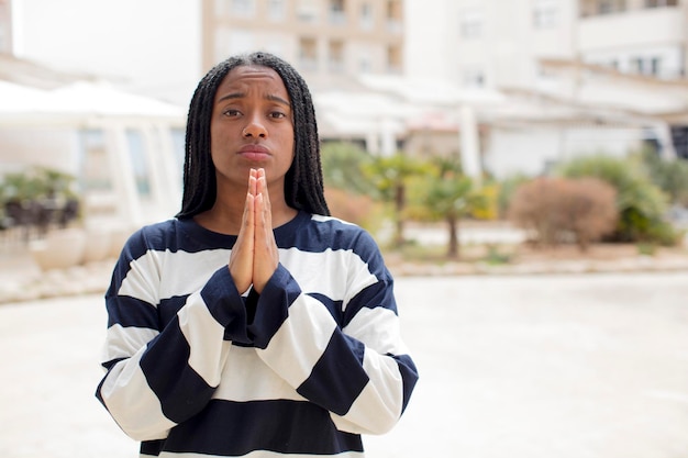 Foto fühlen sie sich besorgt, hoffnungsvoll und religiös, beten sie treu mit gedrückten handflächen und bitten sie um vergebung