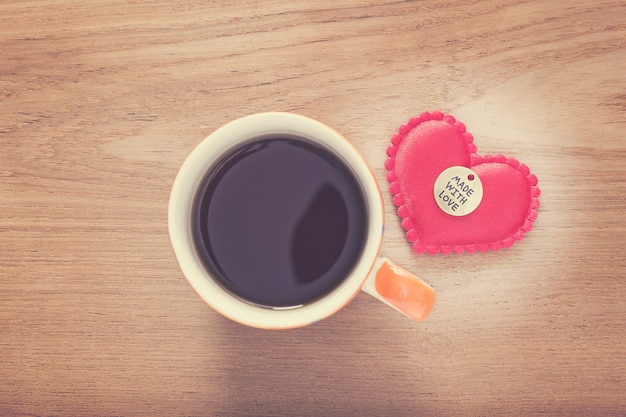 Fühlte Herz mit Made With Love-Taste und Tasse Kaffee auf bewaldeten Tisch