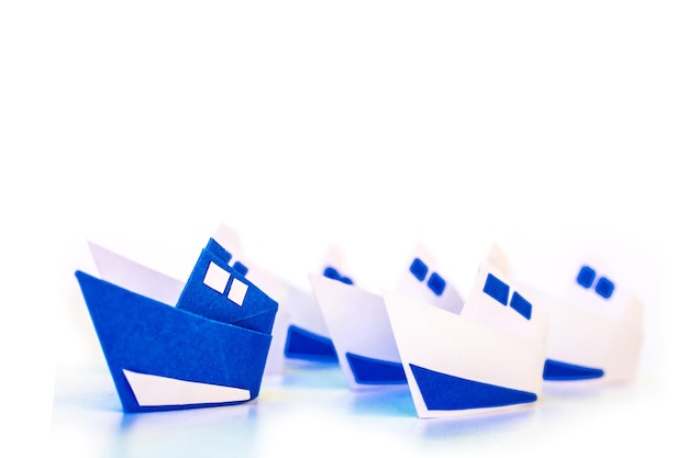 Führungskonzept mit blauem Papierschiff isoliert auf weißem Hintergrund. Führungs- und Managerkonzepte.