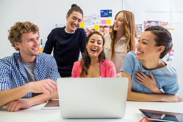 Führungskräfte diskutieren über Laptop im Büro