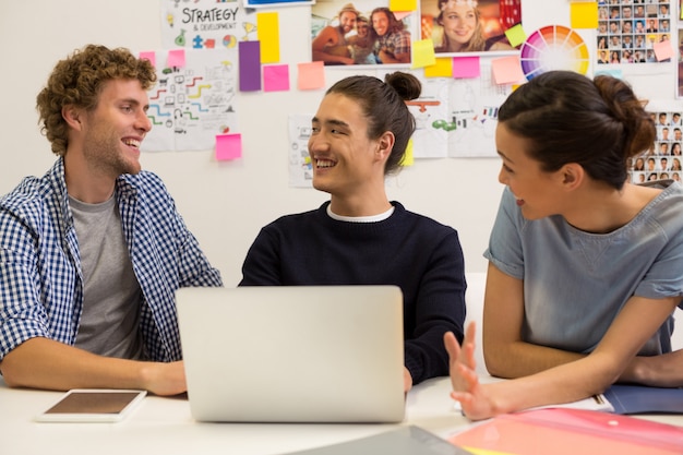 Führungskräfte diskutieren über Laptop im Büro