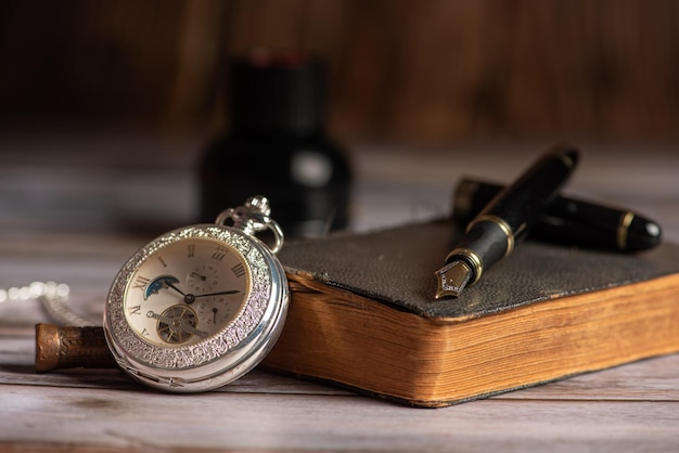 Foto füllfederhalter schöne füllfederhalter in einer umgebung mit einer alten uhr alte buchtinte unter anderem selektiven fokus