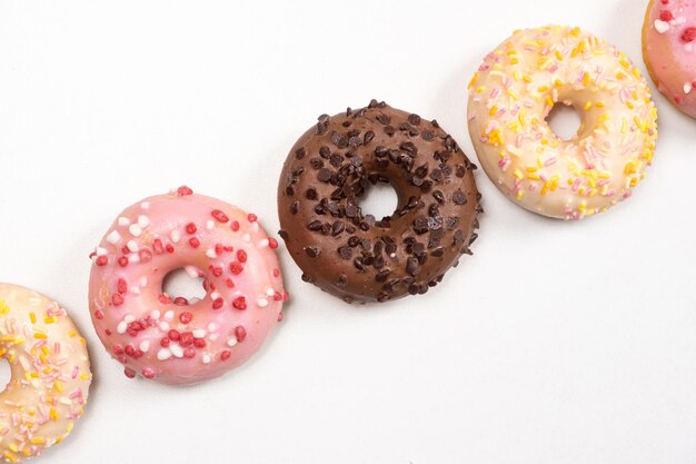 Fünf Donuts hintereinander weiß, rosa und Schokolade