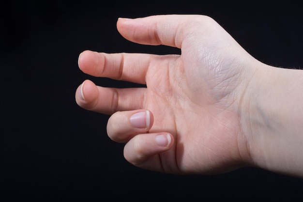 Fünf Finger einer Kinderhand, teilweise auf schwarzem Hintergrund zu sehen