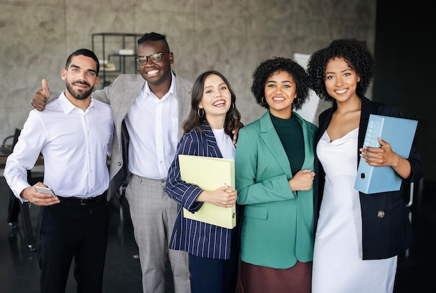 Fünf junge multikulturelle Geschäftsleute und Geschäftsfrauen stehen in einem modernen Büro