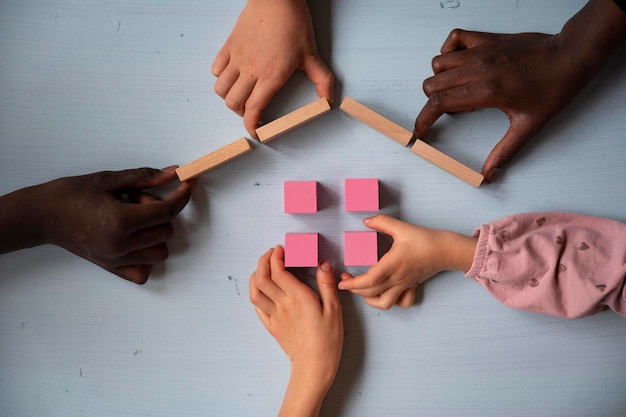 Fünf Kinder bauen ein Haus aus Holzklötzen