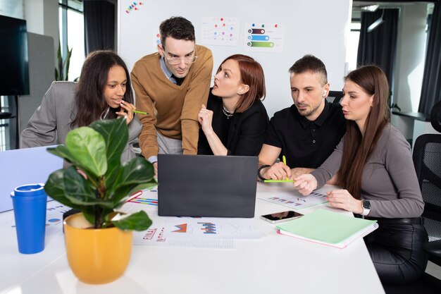 Fünf Kollegen besprechen Arbeitsthemen im Büro