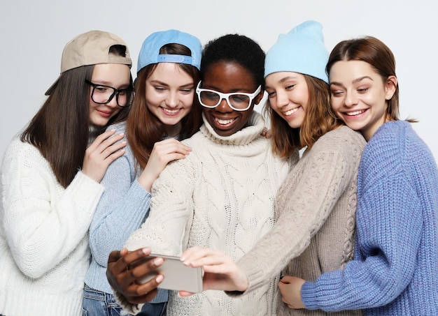 Fünf Mädchen aus verschiedenen Nationen in Freizeitkleidung machen ein Selfie