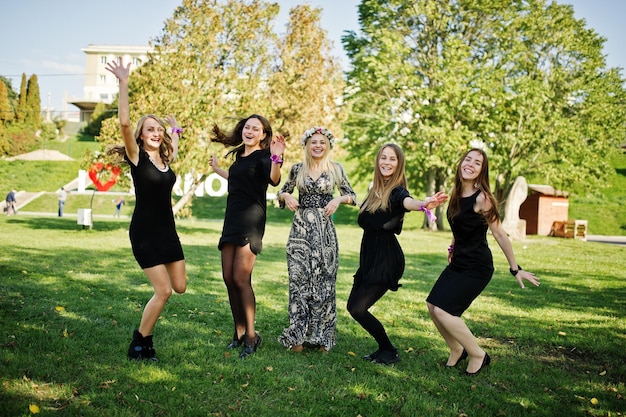 Fünf Mädchen tragen beim Junggesellinnenabschied schwarzes Springen