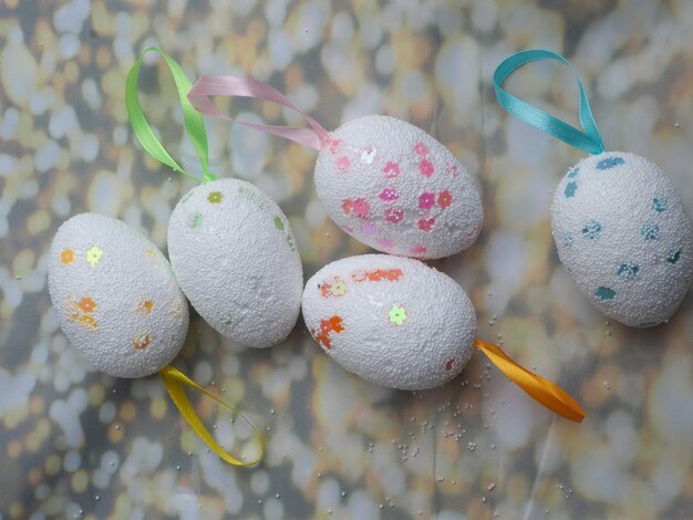 Fünf Ostereier mit einem Band, auf dem "Frohe Ostern" steht.