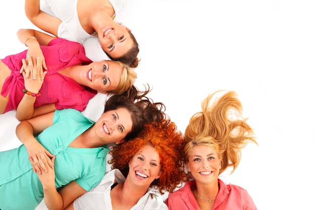 fünf schöne Mädchen liegen auf dem Boden und lächeln über weiß
