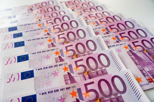 Fünfhundert Eurobanknoten in weißem Hintergrund mit zwei Reihen