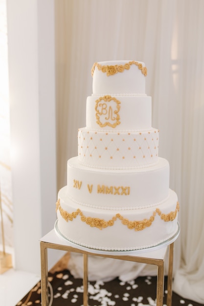 Fünfstöckige weiße Hochzeitstorte im goldenen Stil dekoriert schöne Süße für Bräutigam und Braut