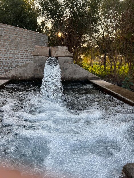 Una fuente de agua con una cascada al fondo