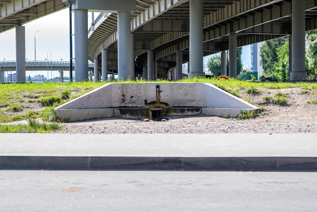 Una fuente de agua limpia en la ciudad cerca de la carretera debajo del puente del automóvil