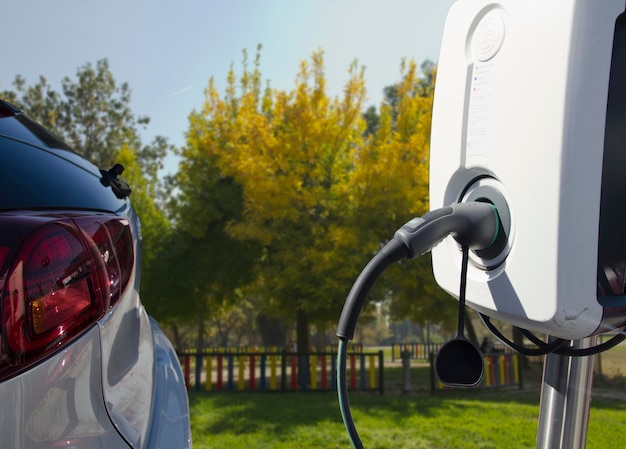 Fuente de alimentación para la carga de coches eléctricos. Estación de carga de coches eléctricos. Primer plano de la fuente de alimentación conectada a un coche eléctrico que se está cargando