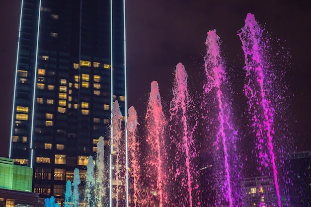 La fuente colorida en el lago por la noche cerca de las Torres Gemelas con la ciudad al fondo Kuala Lumpur Malasia