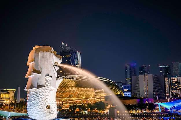 Fuente de la estatua de Merlion en Merlion Park y el horizonte de la ciudad de Singapur por la noche.