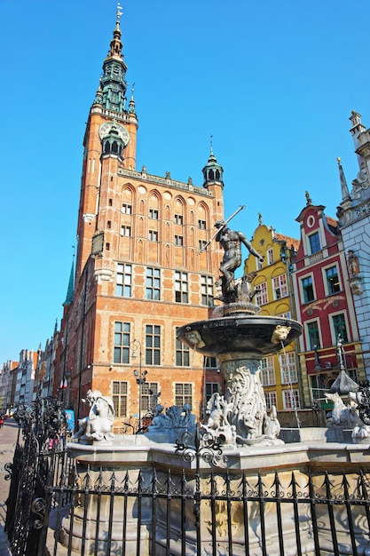 Fuente de Neptuno en el antiguo ayuntamiento principal en la plaza Dlugi Targ en el centro antiguo de la ciudad de Gdansk, Polonia. Gente en el fondo.