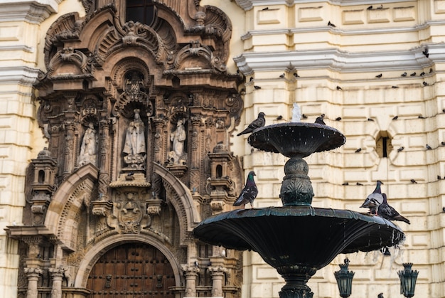 Fuente con palomas frente a la Iglesia de San Francisco en el centro histórico de Lima