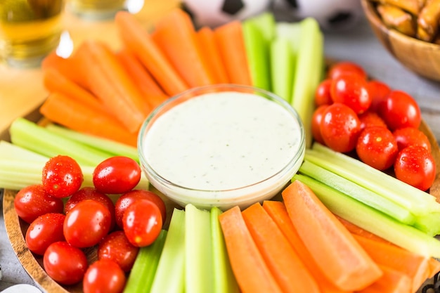 Fuente de verduras con salsa para fiesta de fútbol.