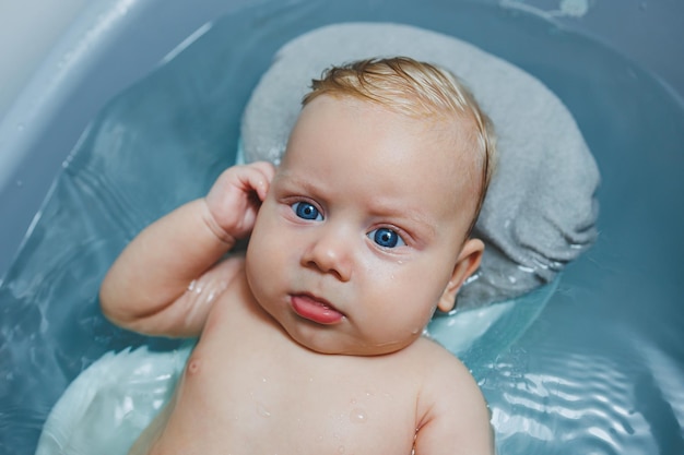 Für ein Neugeborenes sorgen, das Baby baden, ein Baby in einer Badewanne baden, Babys erste Bäder