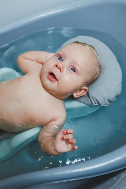 Für ein Neugeborenes sorgen, das Baby baden, ein Baby in einer Badewanne baden, Babys erste Bäder