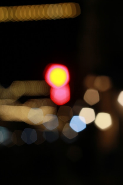 Foto fuera de foco hermoso bokeh borroso brillante de coches y semáforos en la noche.