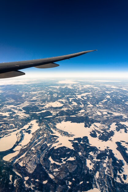 Fuera de la vista superior desde las ventanas laterales del avión cuando sale el sol, el transporte y el viajero