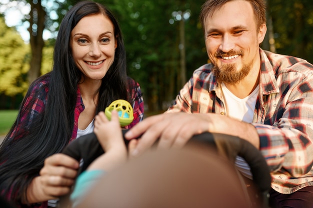 Fürsorgliche Eltern spielen mit kleinem Baby im Sommerpark