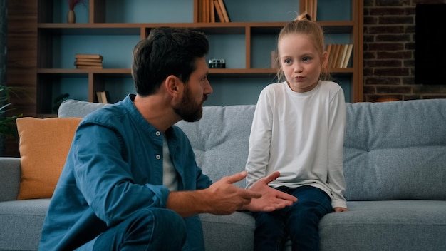 Fürsorglicher Vater, kaukasischer Mann, Vater, der mit beleidigtem Mädchen spricht, das der kleinen Tochterfamilie hilft