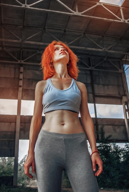 Fuerte atleta femenina vistiendo ropa deportiva tomando un descanso después de hacer ejercicio